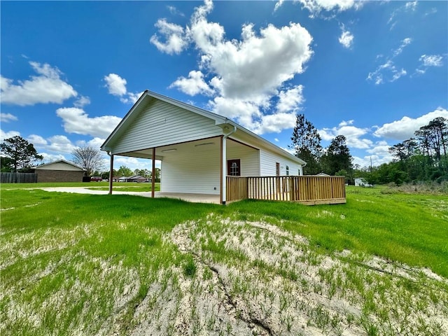 rear view of property featuring a carport and a lawn