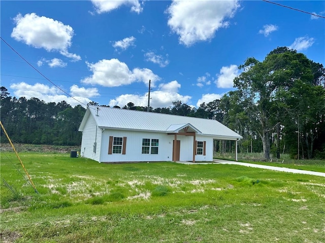 view of front of home featuring metal roof, a front lawn, and a carport