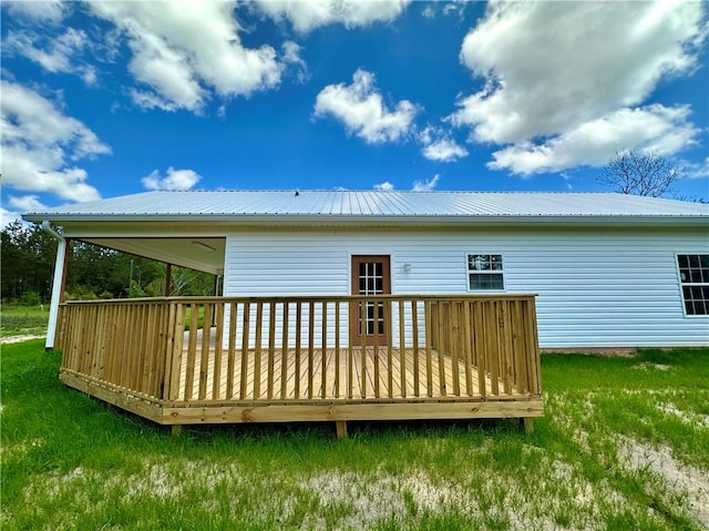 rear view of house with metal roof, a yard, and a deck