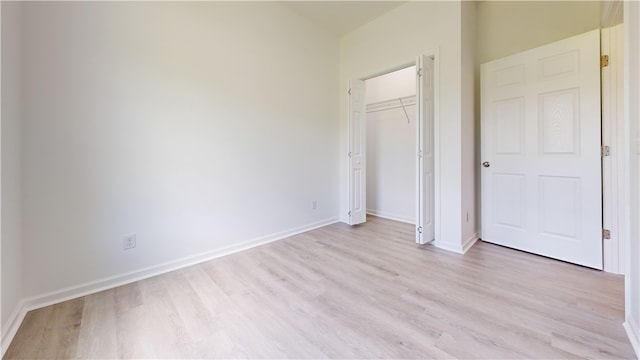 unfurnished bedroom with baseboards, a closet, and light wood-style floors