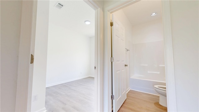 bathroom with recessed lighting, toilet, bathtub / shower combination, visible vents, and wood finished floors