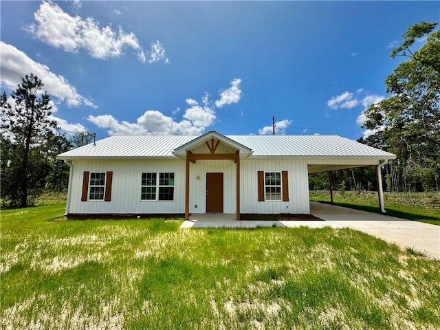 view of front of property with a front yard, an attached carport, and driveway