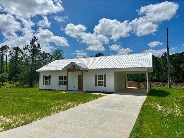 ranch-style house with an attached carport, a front yard, metal roof, and concrete driveway