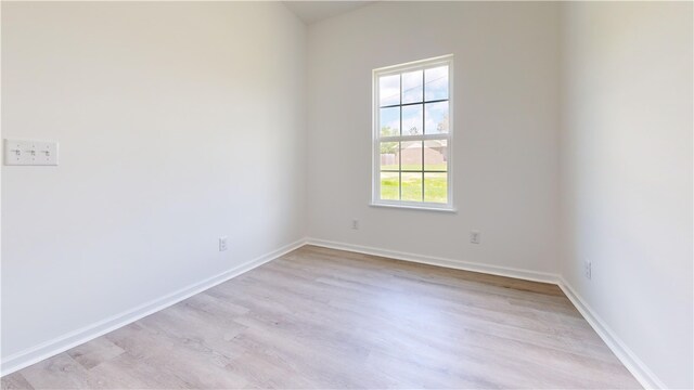 unfurnished room featuring baseboards and light wood-style floors