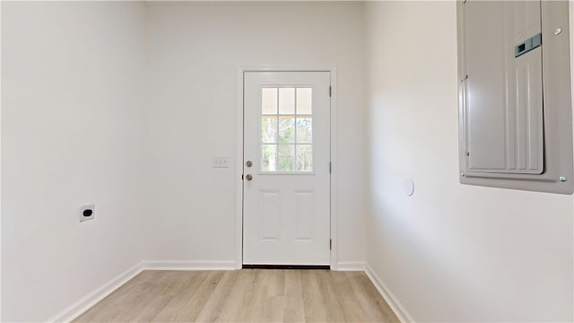 doorway with baseboards, electric panel, and light wood-type flooring