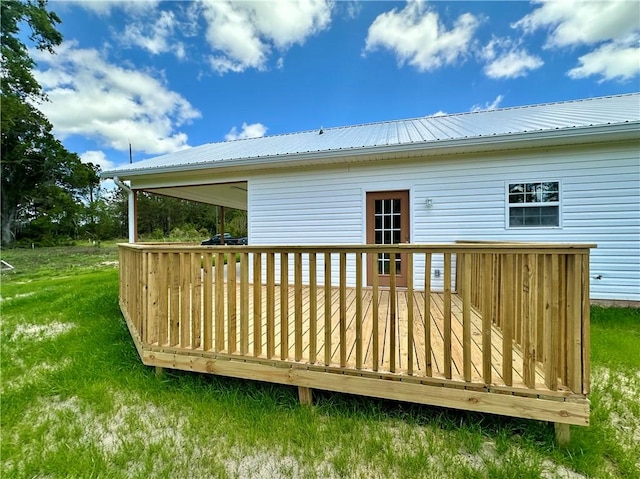 back of house with a lawn, metal roof, and a deck