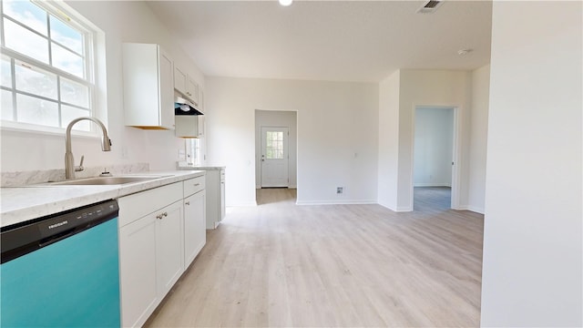kitchen with white cabinetry, light countertops, a sink, light wood finished floors, and dishwashing machine