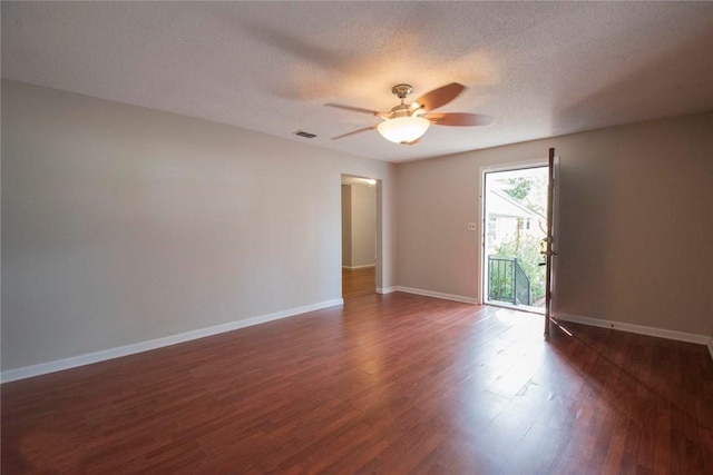 spare room with ceiling fan, dark wood-type flooring, and a textured ceiling