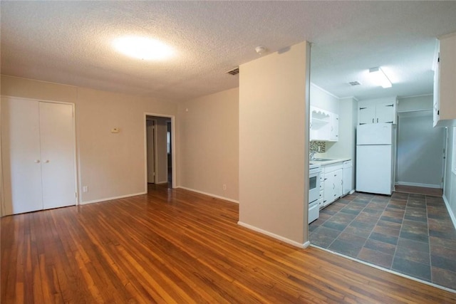 spare room with dark hardwood / wood-style floors, sink, and a textured ceiling