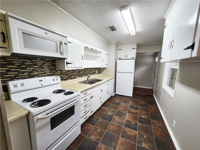 kitchen featuring light countertops, white appliances, decorative backsplash, a sink, and visible vents