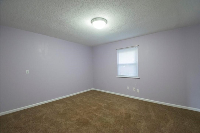 empty room with carpet and a textured ceiling