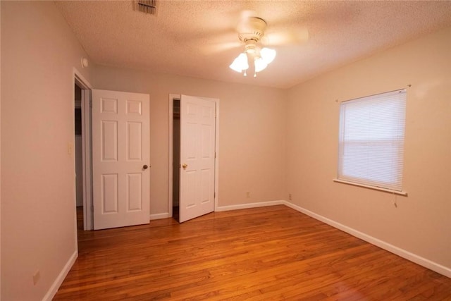 unfurnished bedroom with a textured ceiling, ceiling fan, and light hardwood / wood-style flooring