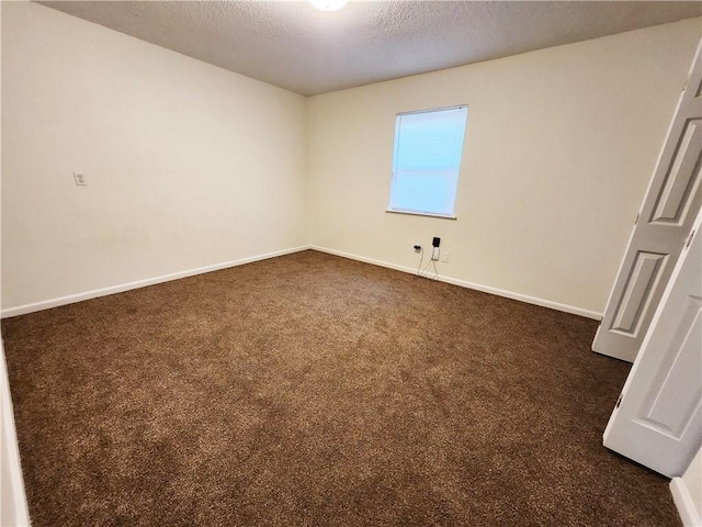 unfurnished bedroom featuring baseboards, dark colored carpet, and a textured ceiling