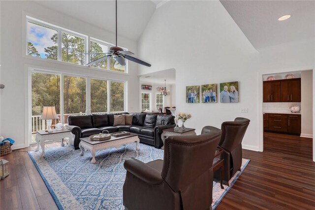 1068 Picnic Ln NE, Townsend, GA 31331 - living room featuring ceiling fan with notable chandelier, baseboards, high vaulted ceiling, and dark wood-type flooring