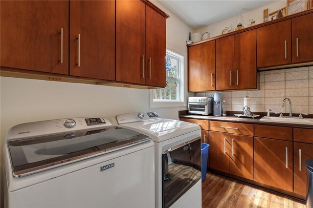 1068 Picnic Ln NE, Townsend, GA 31331 - washroom with washing machine and clothes dryer, light wood-style flooring, a sink, and laundry area