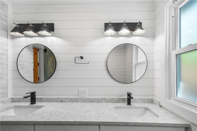 full bathroom with a sink, a wealth of natural light, and double vanity