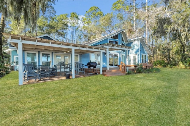 rear view of property featuring a pergola, a patio area, and a lawn