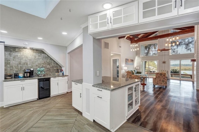 kitchen featuring hardwood / wood-style floors, wine cooler, white cabinets, decorative backsplash, and light stone counters