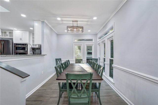 dining space featuring dark wood-type flooring and ornamental molding