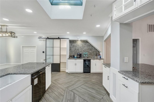 kitchen with white cabinetry, dishwasher, wine cooler, light stone counters, and a barn door