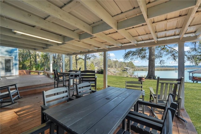 wooden deck with a water view and a lawn