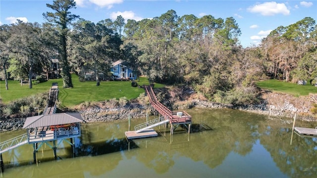 view of dock with a yard and a water view