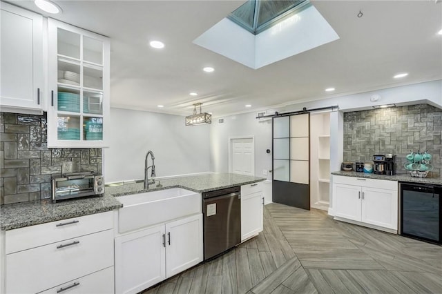 kitchen with sink, a barn door, stainless steel dishwasher, beverage cooler, and white cabinets