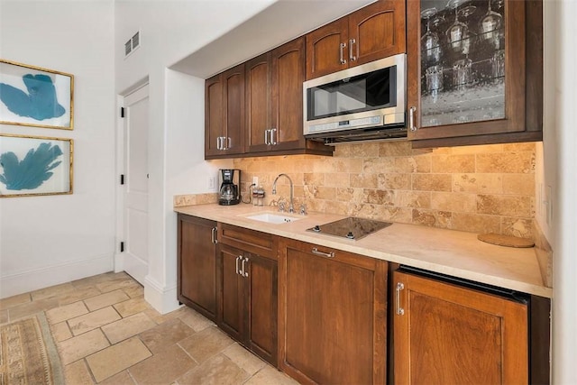 600 Beach Club Dr Unit 623/624, Sea Island, GA 31561 - bar area featuring stainless steel microwave, black electric stovetop, tasteful backsplash, and light stone finish flooring