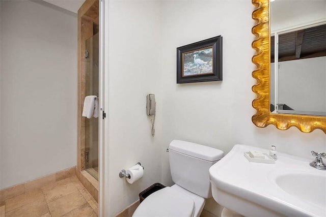 bathroom featuring sink, an enclosed shower, and toilet