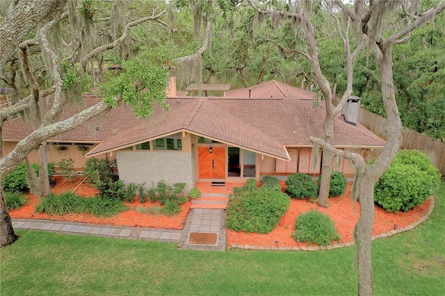 105 Driftwood Pl, Saint Simons Island, GA 31522 - mid-century home with a chimney, stucco siding, and a shingled roof