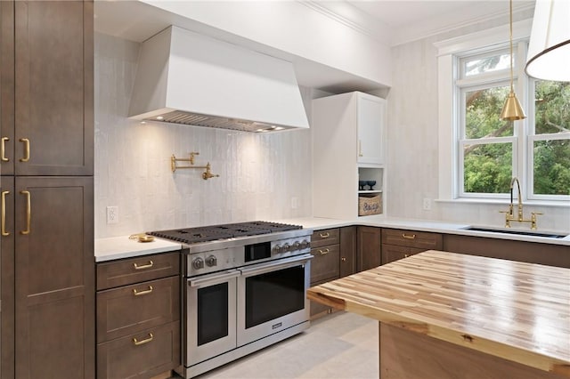 50 Frederica Oaks Ln, Saint Simons Island, GA 31522 - kitchen featuring double oven range, wooden counters, a sink, wall chimney exhaust hood, and decorative backsplash