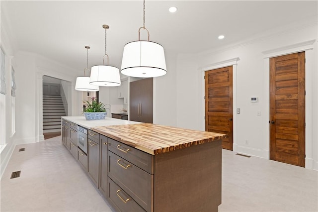 50 Frederica Oaks Ln, Saint Simons Island, GA 31522 - kitchen with butcher block counters, recessed lighting, a kitchen island, decorative light fixtures, and ornamental molding