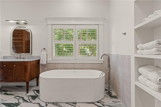 50 Frederica Oaks Ln, Saint Simons Island, GA 31522 - full bath with tile walls, vanity, a freestanding bath, wainscoting, and marble look tile flooring