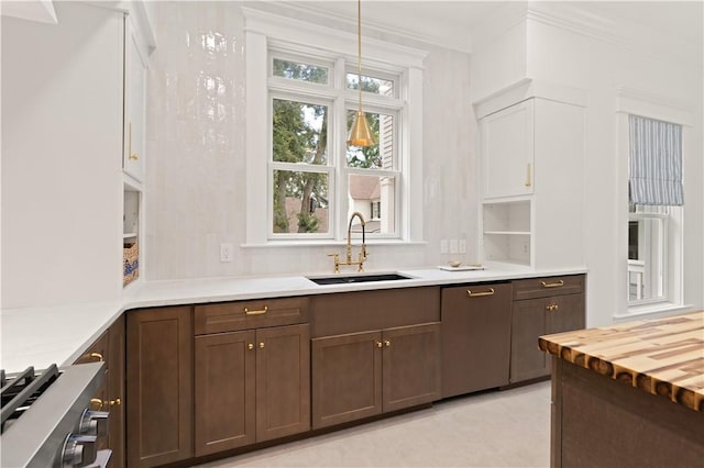 50 Frederica Oaks Ln, Saint Simons Island, GA 31522 - kitchen with stainless steel dishwasher, stove, decorative light fixtures, and crown molding