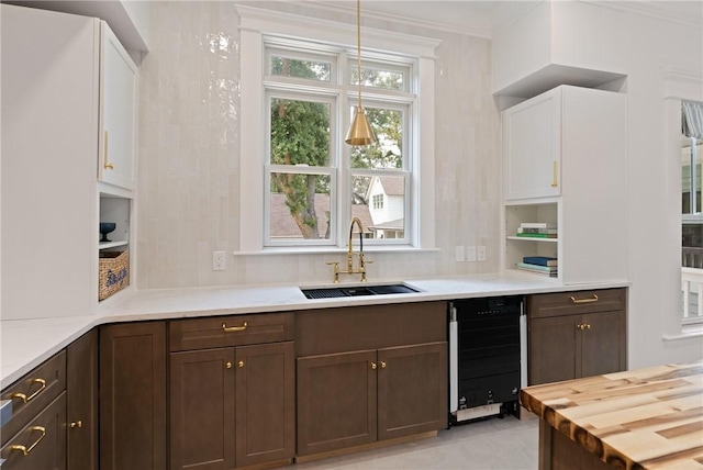 50 Frederica Oaks Ln, Saint Simons Island, GA 31522 - kitchen with a sink, wine cooler, wooden counters, plenty of natural light, and ornamental molding