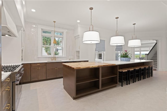 50 Frederica Oaks Ln, Saint Simons Island, GA 31522 - kitchen with range with two ovens, custom exhaust hood, open shelves, butcher block counters, and a center island