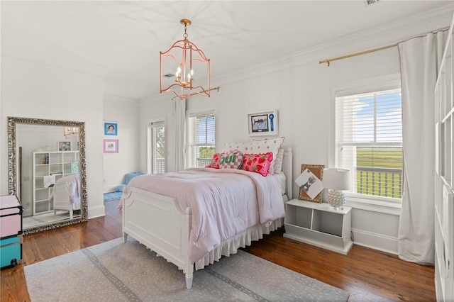 50 Frederica Oaks Ln, Saint Simons Island, GA 31522 - bedroom featuring a chandelier, wood finished floors, crown molding, and baseboards