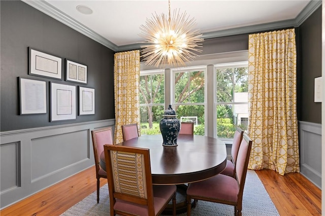 50 Frederica Oaks Ln, Saint Simons Island, GA 31522 - dining area featuring a chandelier, crown molding, wood finished floors, healthy amount of natural light, and a decorative wall