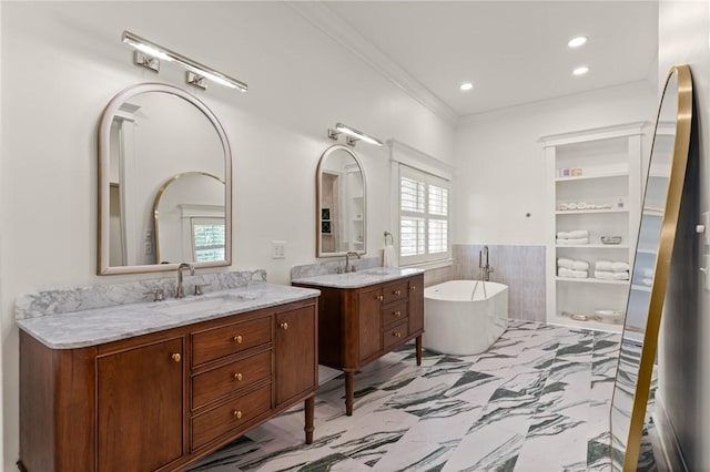 50 Frederica Oaks Ln, Saint Simons Island, GA 31522 - full bath with two vanities, a soaking tub, crown molding, plenty of natural light, and wainscoting
