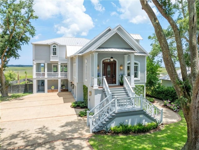 50 Frederica Oaks Ln, Saint Simons Island, GA 31522 - view of front of home featuring a porch, stairs, driveway, metal roof, and a standing seam roof