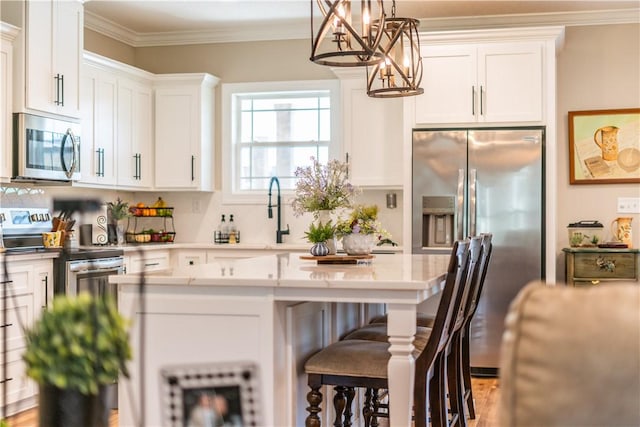 121 Farms Edge Rd S, Manor, GA 31550 - kitchen featuring stainless steel appliances, a chandelier, a kitchen bar, white cabinetry, and pendant lighting