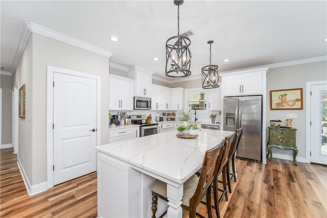 121 Farms Edge Rd S, Manor, GA 31550 - kitchen featuring stainless steel appliances, a chandelier, crown molding, a center island, and white cabinets