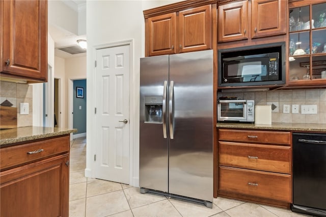 kitchen with light stone countertops, light tile patterned floors, backsplash, and black appliances