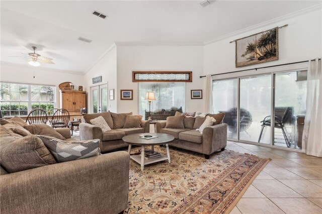 living room with ceiling fan, light tile patterned flooring, lofted ceiling, and crown molding