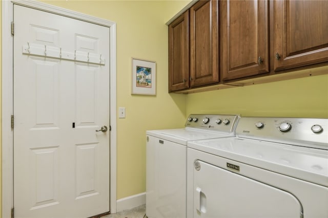 laundry room with cabinets and washer and clothes dryer