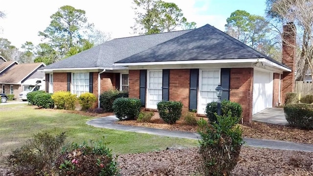 ranch-style house with a shingled roof, a front yard, brick siding, and a chimney