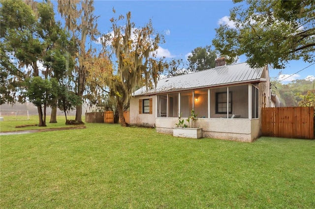 view of front of property with a sunroom and a front yard