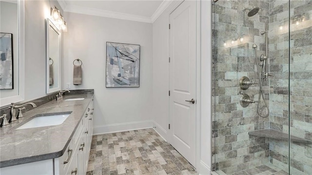 bathroom with crown molding, baseboards, a sink, and a shower stall