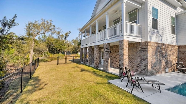 view of side of property featuring a yard, brick siding, a patio area, and a fenced backyard