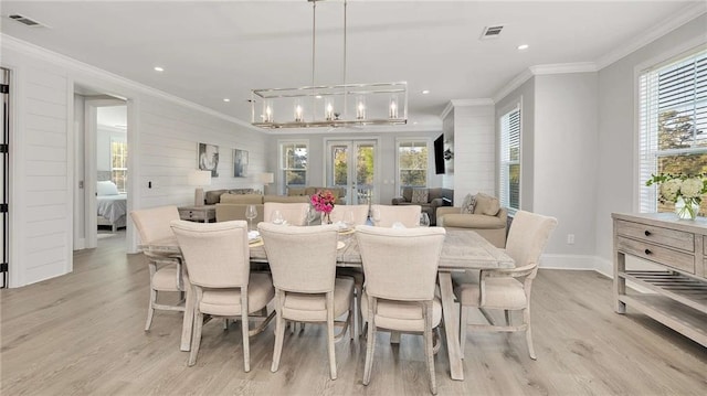 dining area featuring a chandelier, ornamental molding, light wood-style flooring, and visible vents